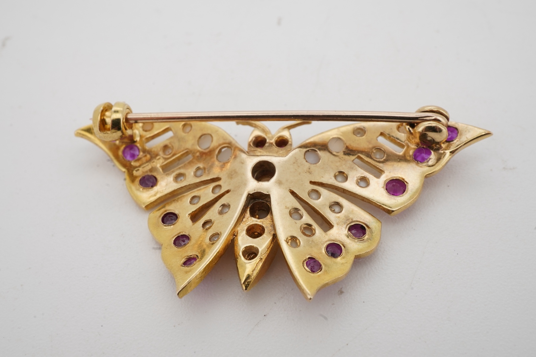 A ruby and split pearl butterfly brooch, set with half pearls and circular-cut rubies, mounted in 9ct gold, wingspan 4cm, British hallmarks, gross weight approximately 6 grams, pearls untested
